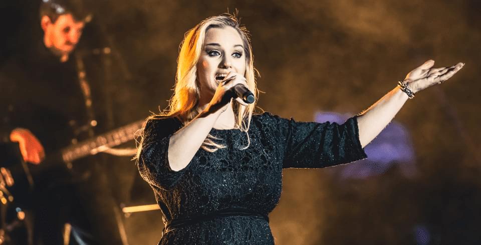 A close up of a female performer singing into a microphone.