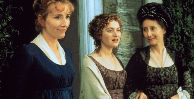 three women dressed in period clothing stood outside a doorway.