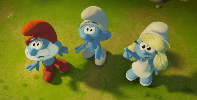 Three animated blue smurfs stand in grass looking up