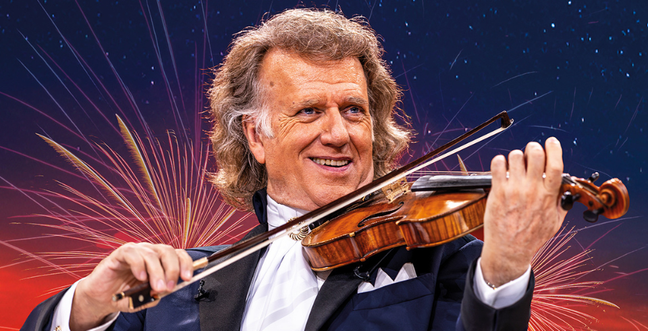 Andre Rieu holds a violin against a background of fireworks