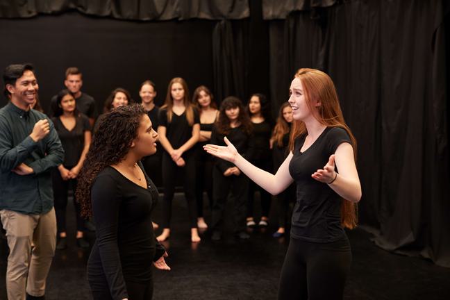 Group of actors acting in a rehearsal space