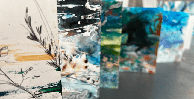 Five abstract colourful pieces of art stand up in a row