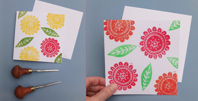 A floral print on a grey backdrop with two lino cutters with wooden handles beside the print