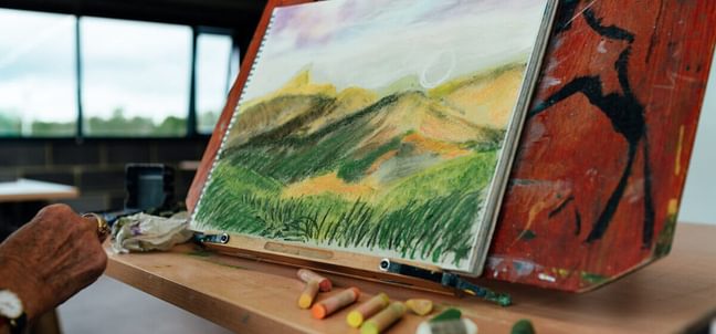 A pastel landscape drawing on an easel