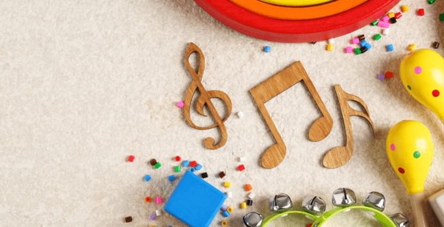 Some wooden music notes alongside maracas and a tambourine.